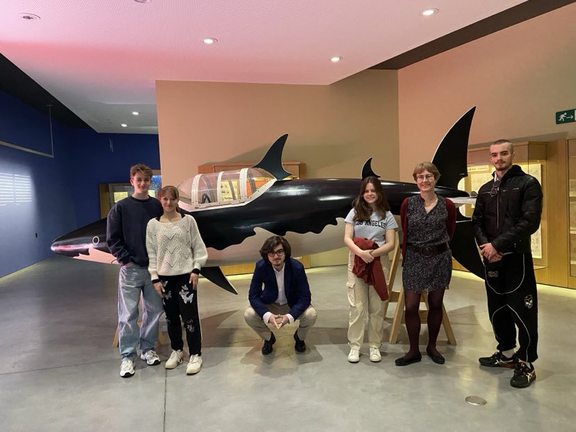 Cinq élèves et une professeure posent devant le sous-marin requin du musée tintin.